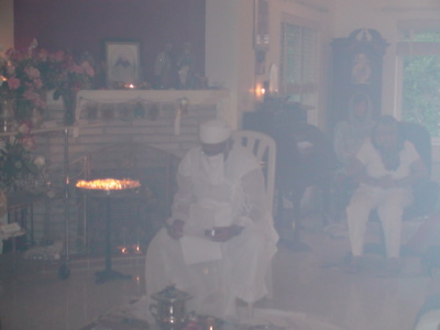 Mobed surrounded by smoke and trying to read names of the departed in the Jashan prayer.